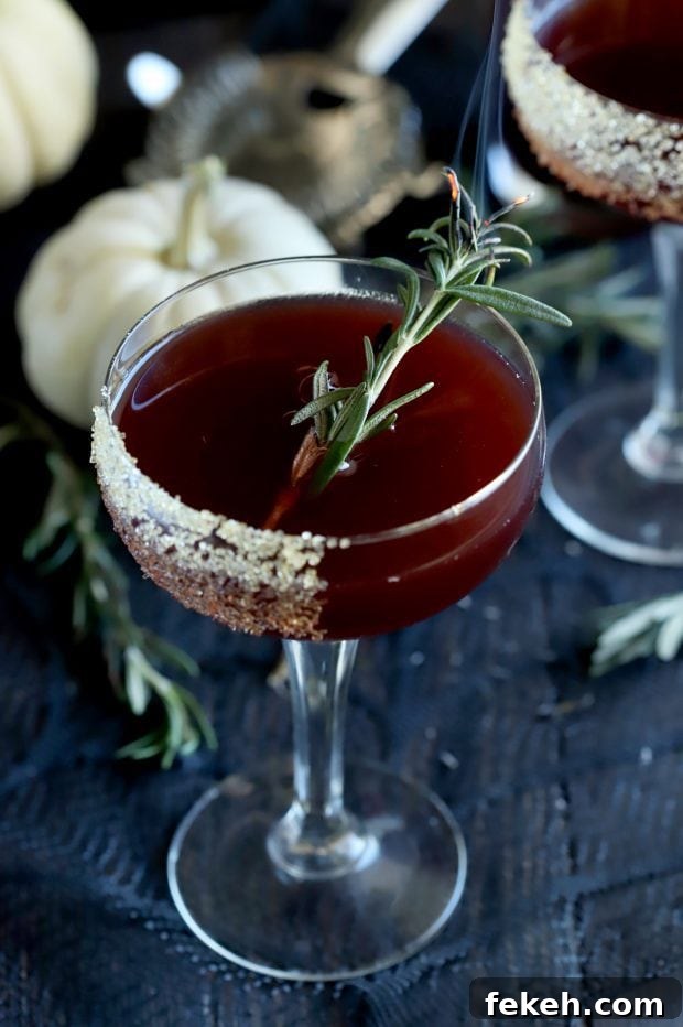 Pomegranate Mezcal Cocktail Recipe for Halloween Parties 8 Spooky Pomegranate Mezcal Cocktail with smoking rosemary in the coupe glass
