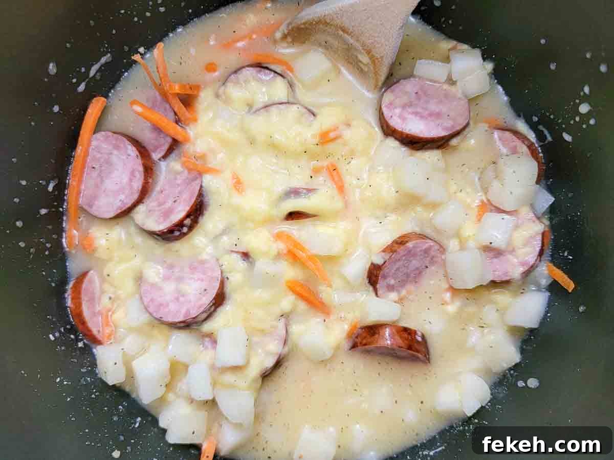 Cheesy Kielbasa and Potato Soup Recipe for Cozy Nights 3 sliced kielbasa, carrots, the minced garlic, cream of chicken soup, hash brown potatoes, beer, salt, and pepper in a saucepan.