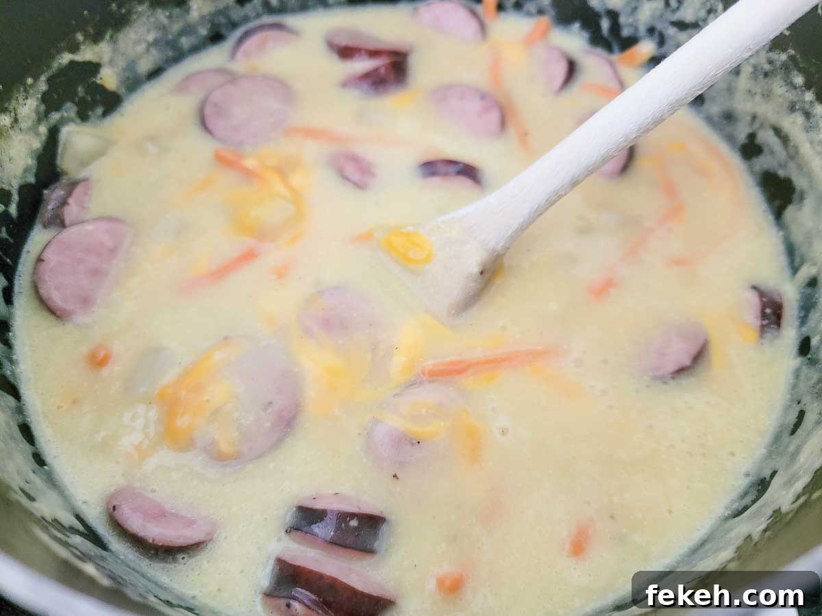 Cheesy Kielbasa and Potato Soup Recipe for Cozy Nights 4 cheddar cheese, sliced kielbasa, carrots, the minced garlic, cream of chicken soup, hash brown potatoes, beer, salt, and pepper in a saucepan.