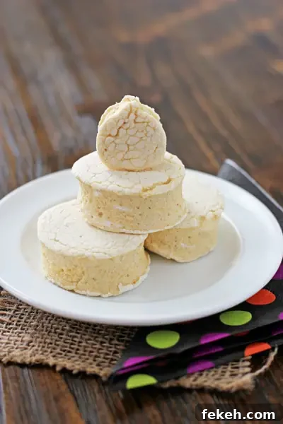 These soft and fluffy homemade pumpkin spice marshmallows are perfect for Fall! Filled with pumpkin puree and plenty of warm spices, these marshmallows are so fun for s'mores! Several Homemade Pumpkin Spice Marshmallows stacked on a white plate.