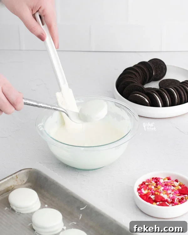 an Oreo being dipped in white chocolate