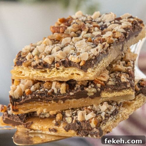 Close-up stack of saltine toffee pieces on a serving spatula.