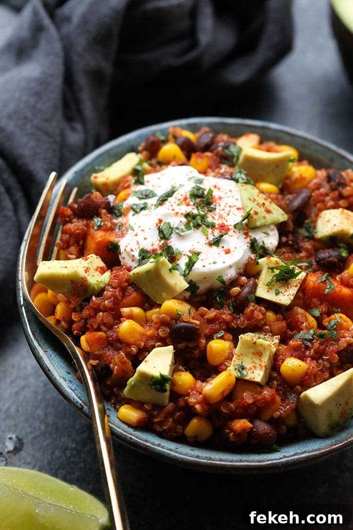 Make our Mexican quinoa recipe in the crockpot for a hands-off, easy meal that's gluten-free and vegan! Bowl of Mexican quinoa with yogurt, paprika, cilantro, and avocado on top