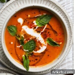 Creamy Vegan Roasted Tomato and Basil Soup Recipe 5 A bowl of roasted tomato basil soup with cream and fresh basil garnish.