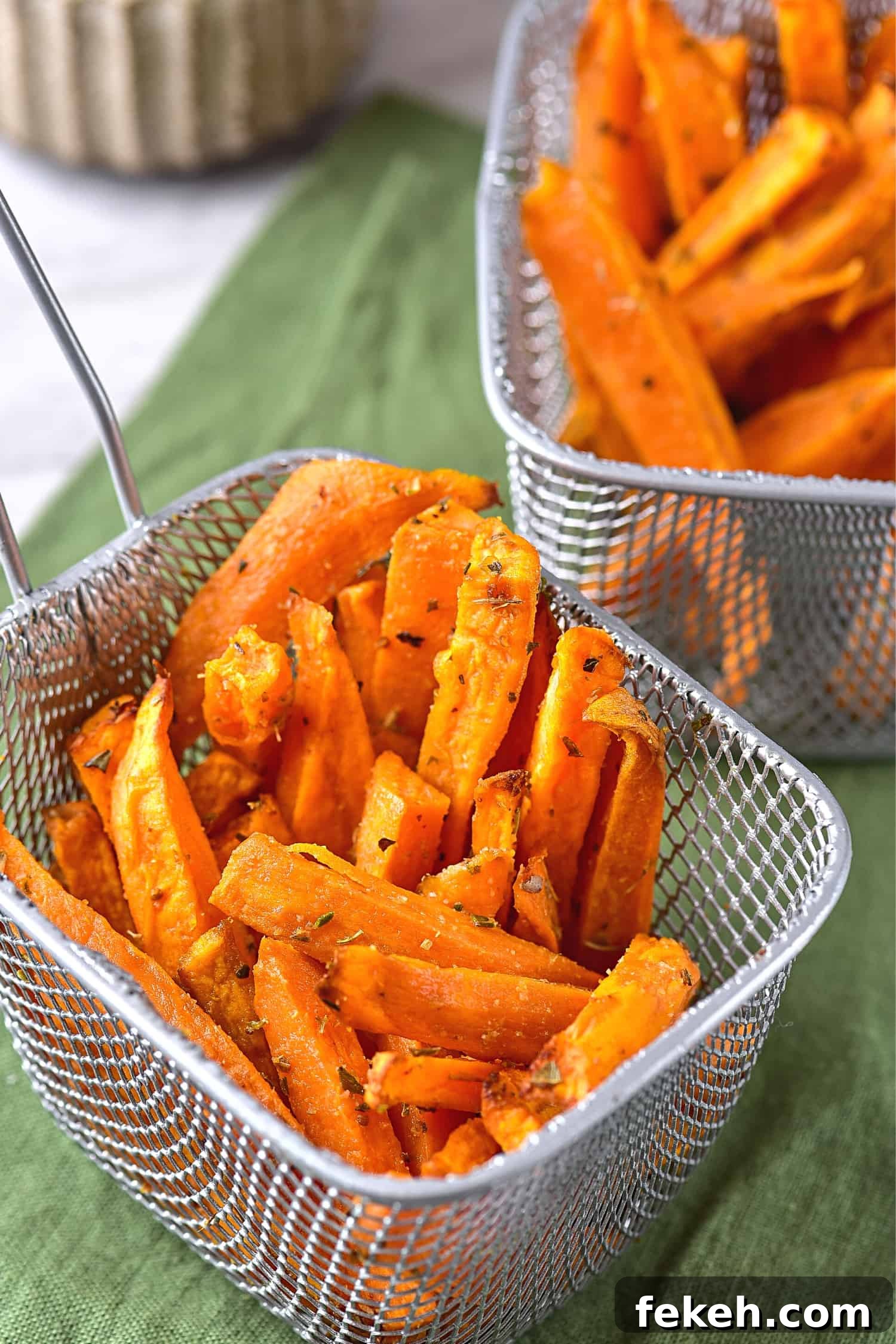 Up close shot of air fried sweet potato wedges in metal basket.