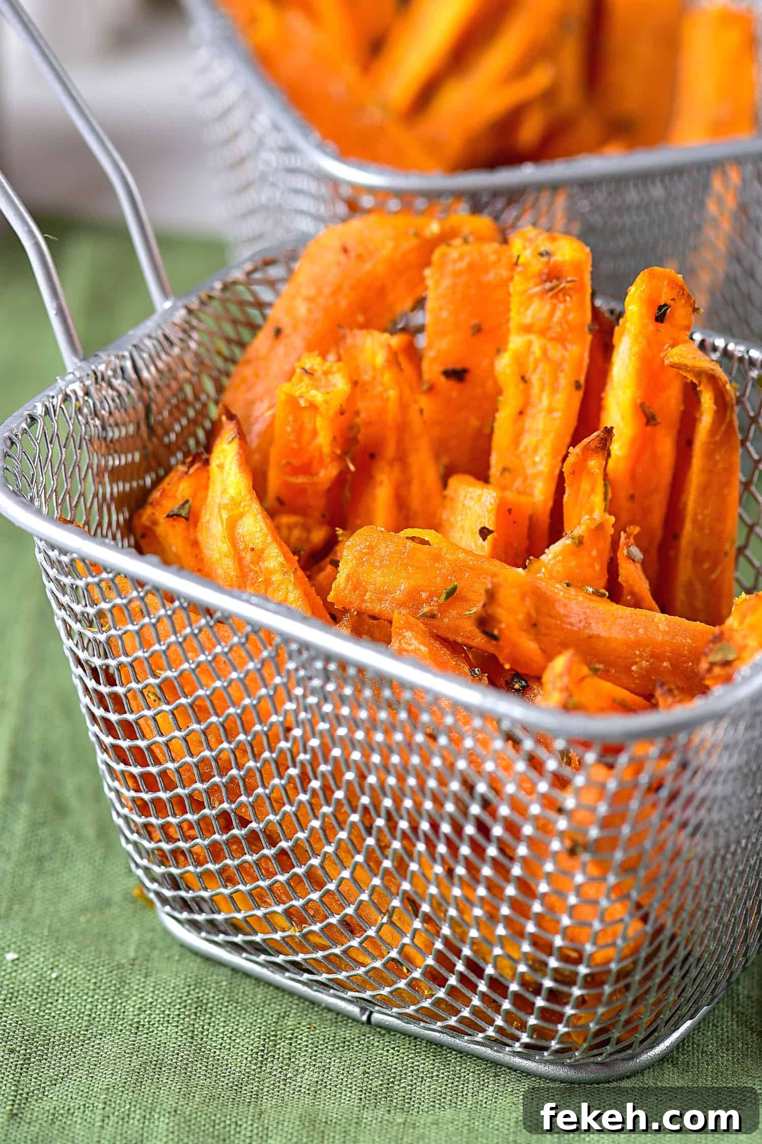 Up close shot of a metal basket with sweet potato wedges.
