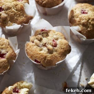 Strawberry Almond Muffins Recipe with Crispy Streusel Topping 13 Strawberry Almond Muffins on white parchment paper.