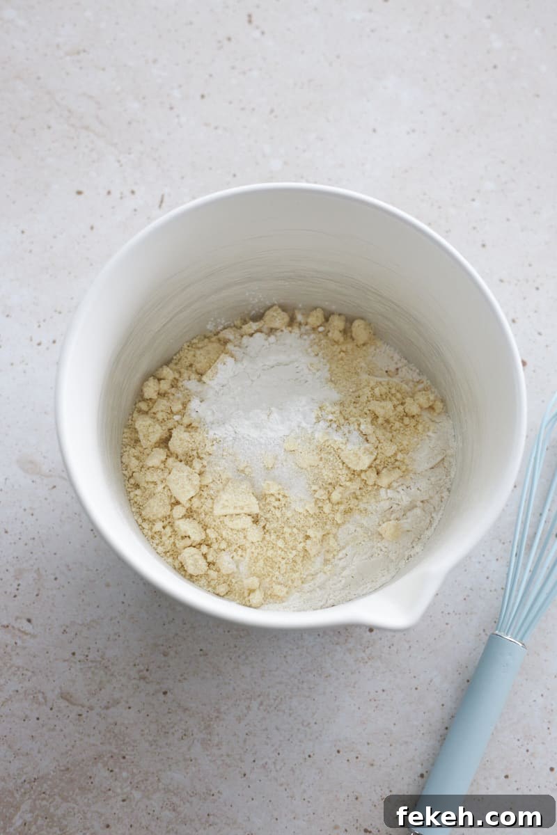 Strawberry Almond Muffins Recipe with Crispy Streusel Topping 7 Dry ingredients in a white mixing bowl.