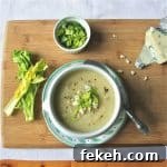 Creamy Celery Root Soup with Gorgonzola and Chives 2 A bowl of celery root soup, topped with celery tops, gorgonzola cheese and ground black pepper.