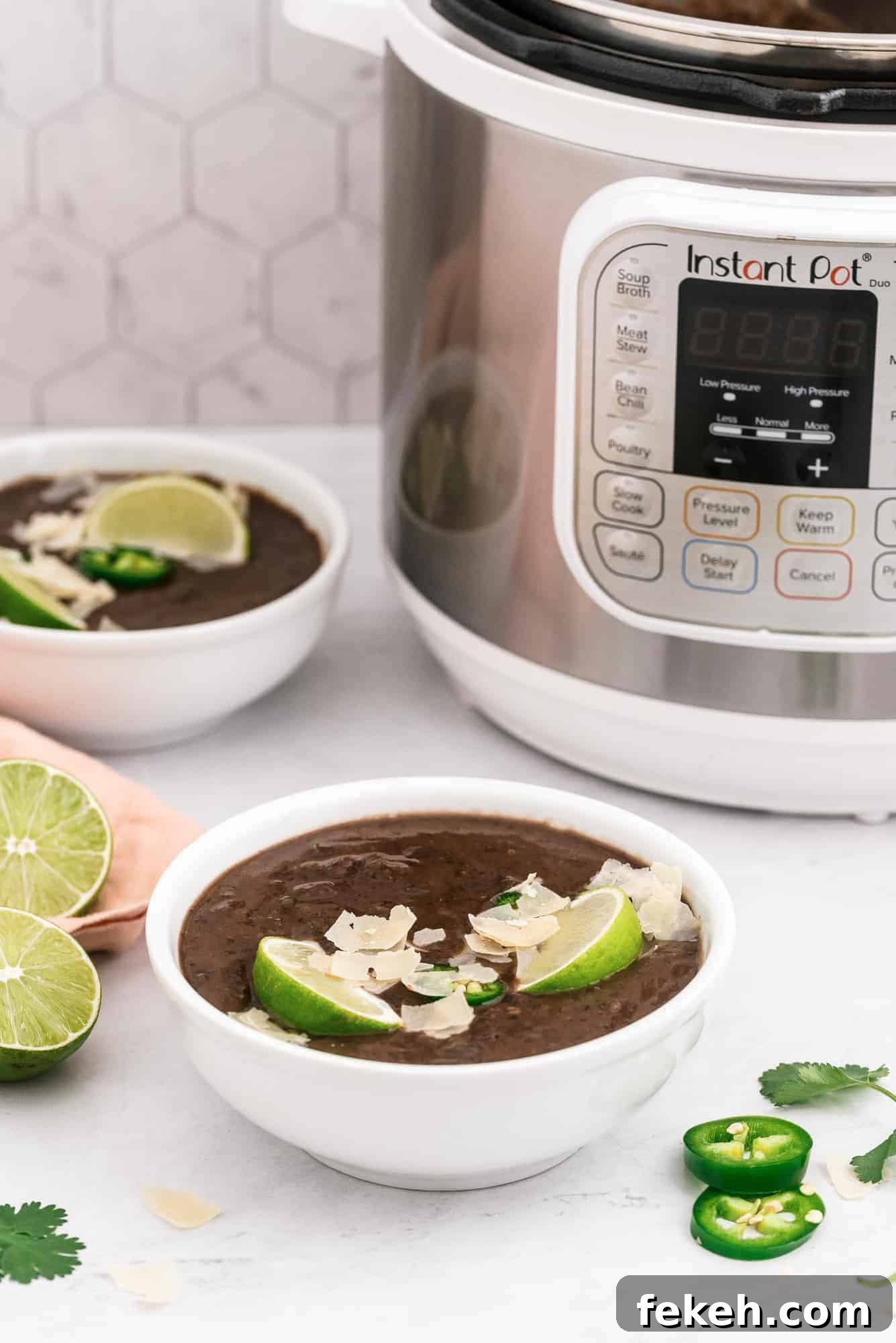 Instant Pot Black Bean Soup with Soaked or Dry Beans 3 Two bowls of soup in front of an instant pot.