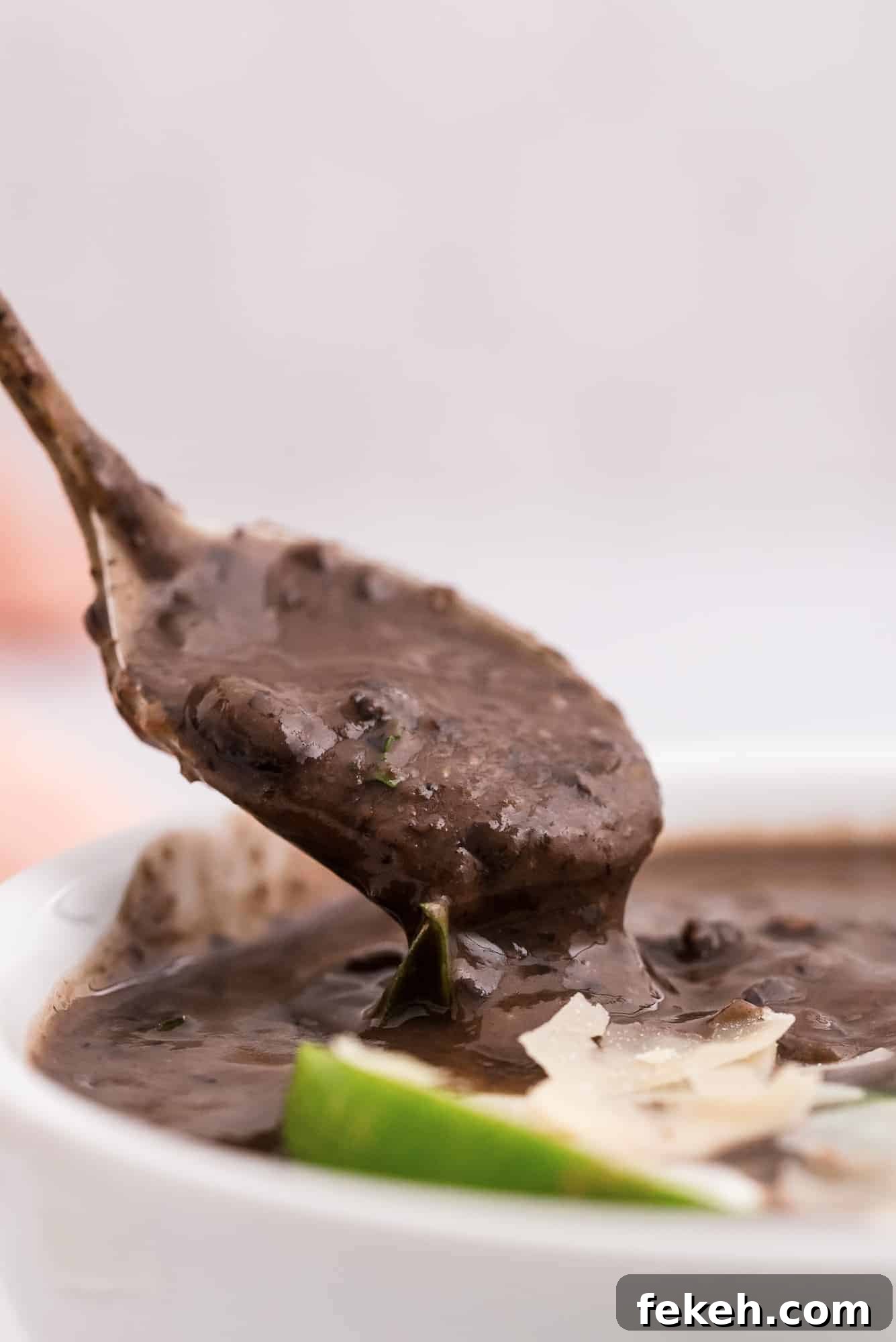 Instant Pot Black Bean Soup with Soaked or Dry Beans 8 Black bean soup on a spoon, being pulled out of a bowl.