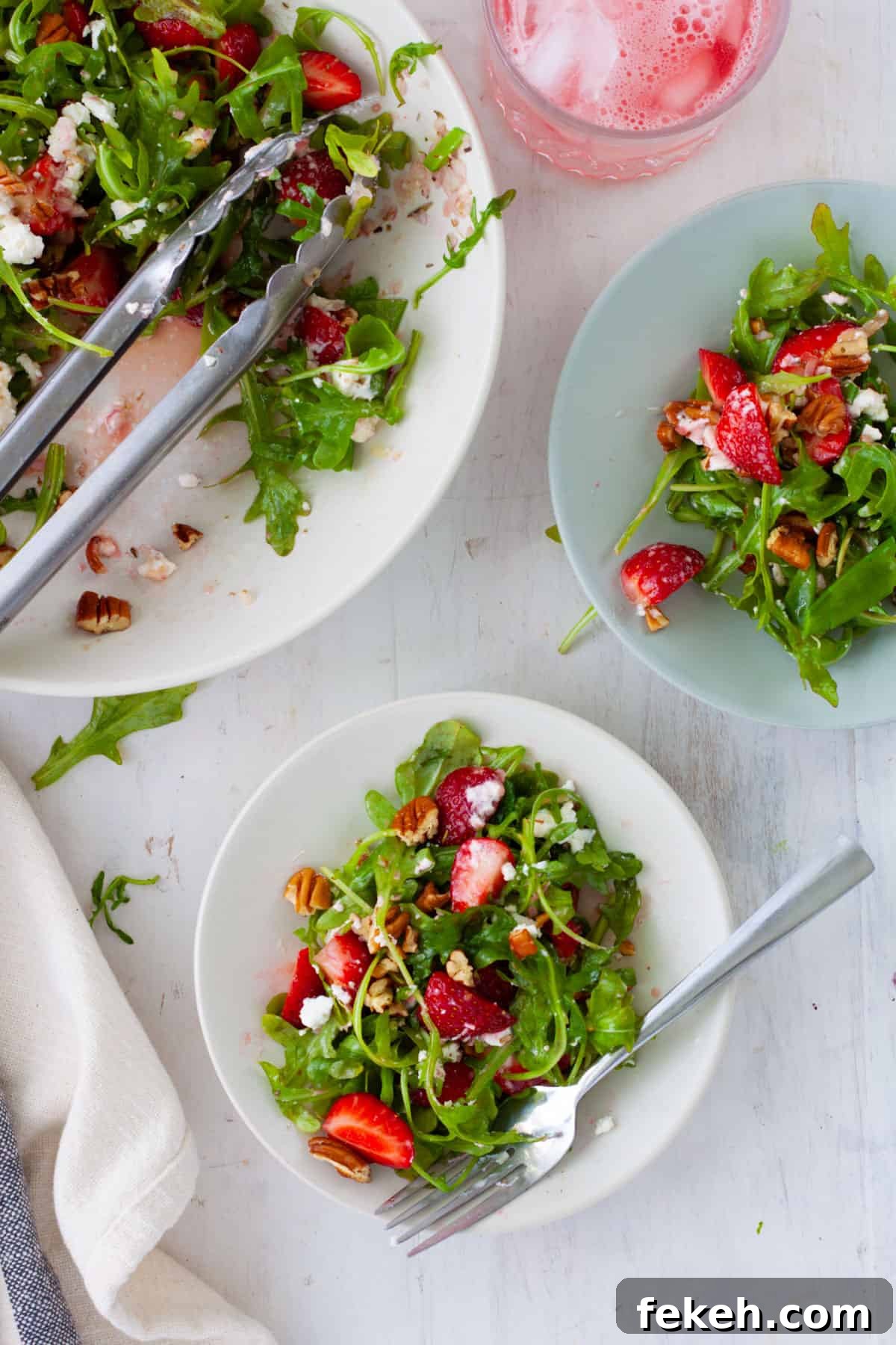 Strawberry Goat Cheese Salad with Balsamic Glaze 2 A bowl of strawberry and goat cheese salad with a couple servings on small plates.