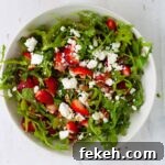 Strawberry and goat cheese salad in a white mixing bowl.