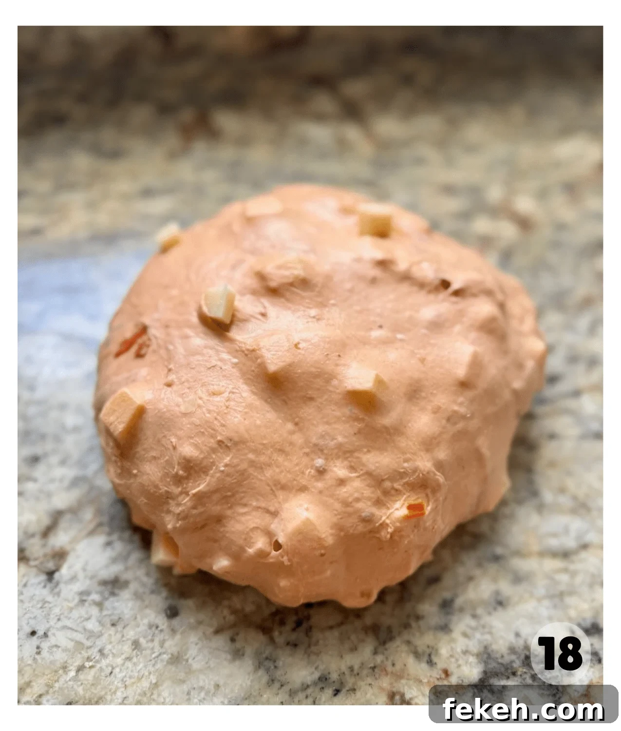 Sourdough Pizza Bread Recipe for Crispy, Flavorful Crust 11 A ball of dough with mozzarella and pepperoni chunks visible rests on a kitchen counter.