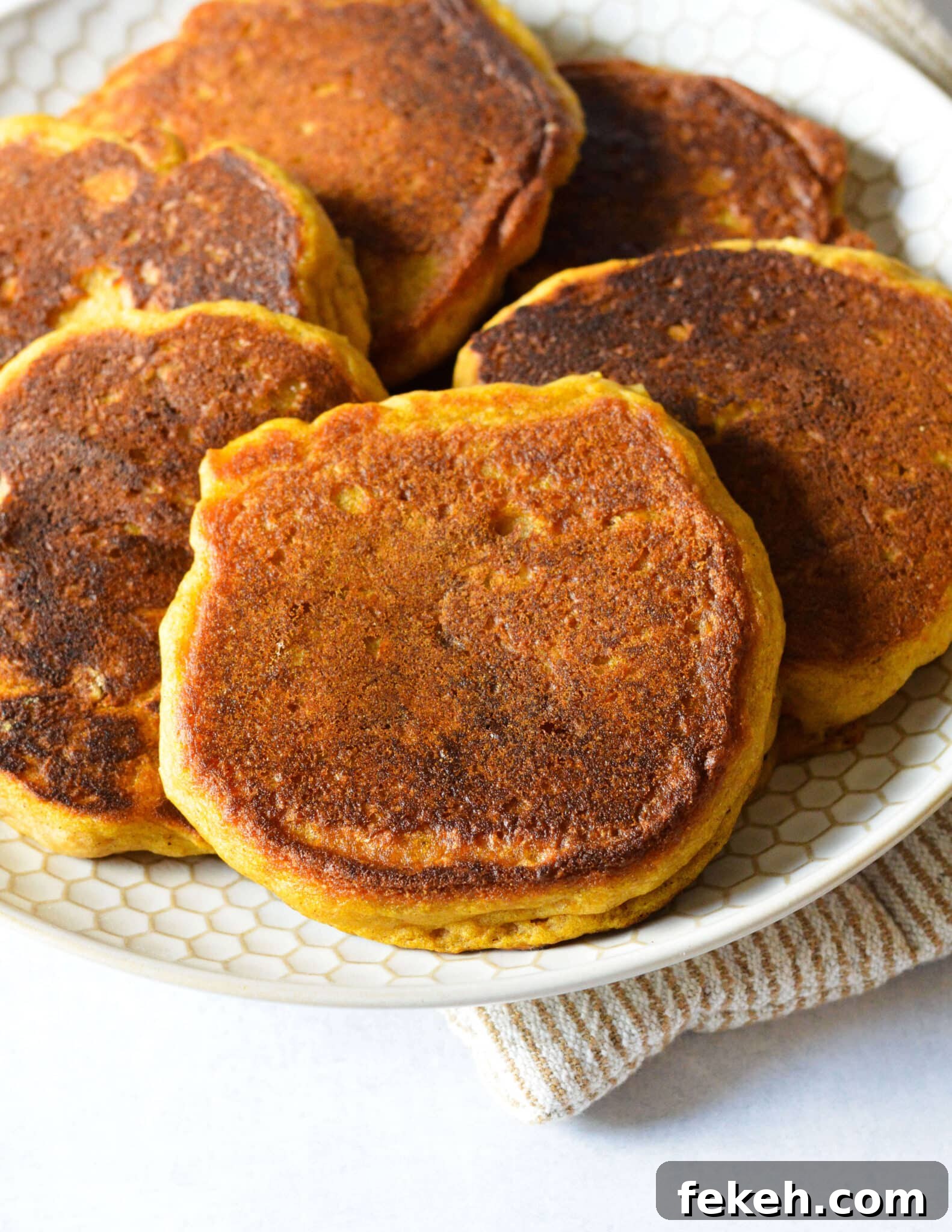 Gluten-Free Pumpkin Pancakes Recipe for Fluffy Fall Mornings 3 a plate full of gluten free pumpkin pancakes.