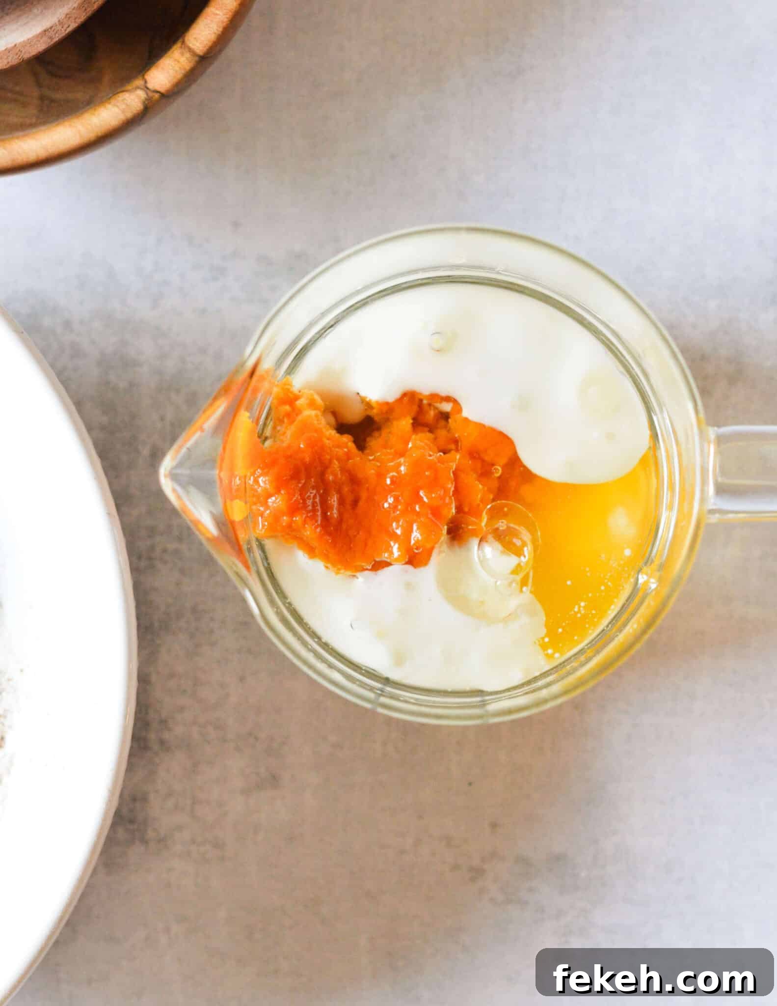 Gluten-Free Pumpkin Pancakes Recipe for Fluffy Fall Mornings 5 pumpkin puree, buttermilk, egg, and oil in a glass measuring cup.