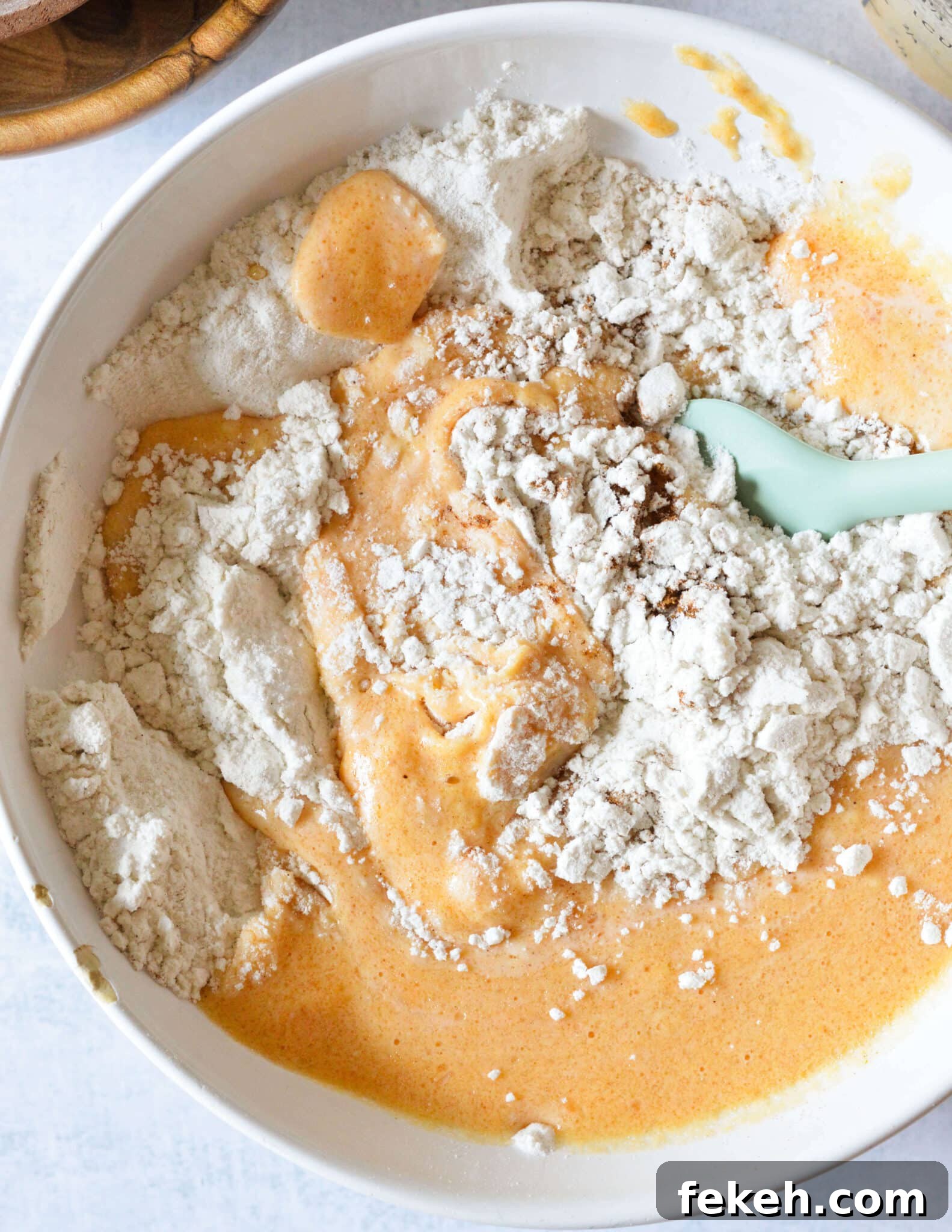 Gluten-Free Pumpkin Pancakes Recipe for Fluffy Fall Mornings 7 a bowl of gluten free flour being mixed with pumpkin, egg, and oil.