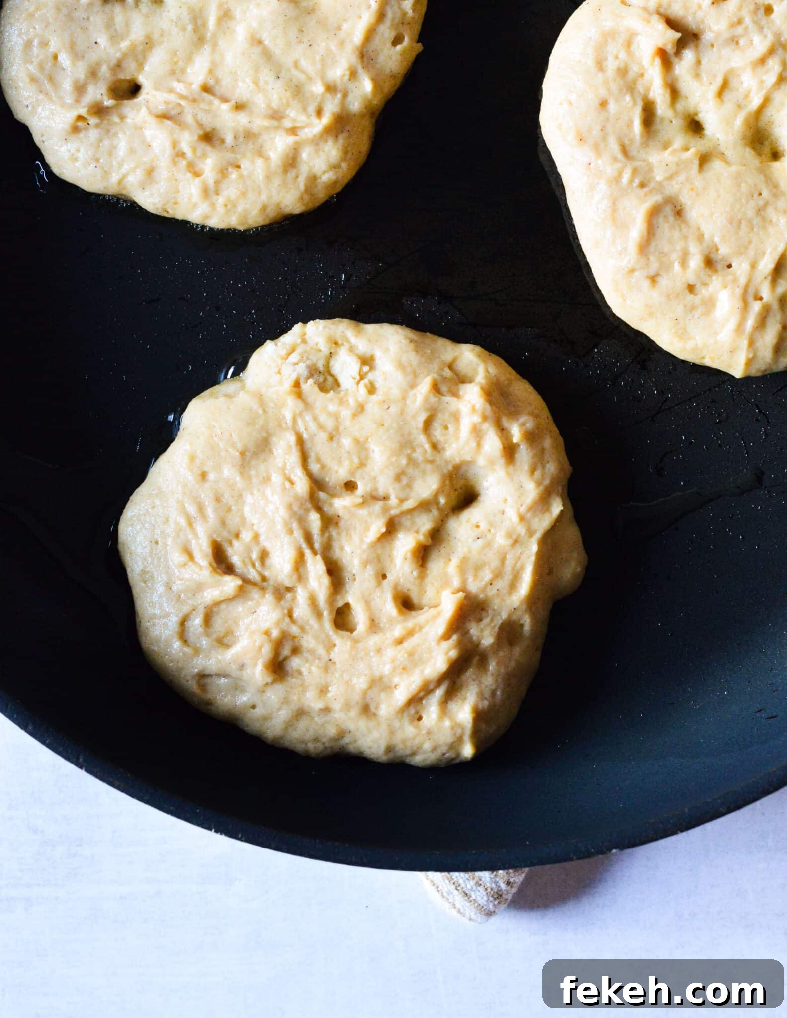 Gluten-Free Pumpkin Pancakes Recipe for Fluffy Fall Mornings 9 pancake batter in a skillet.