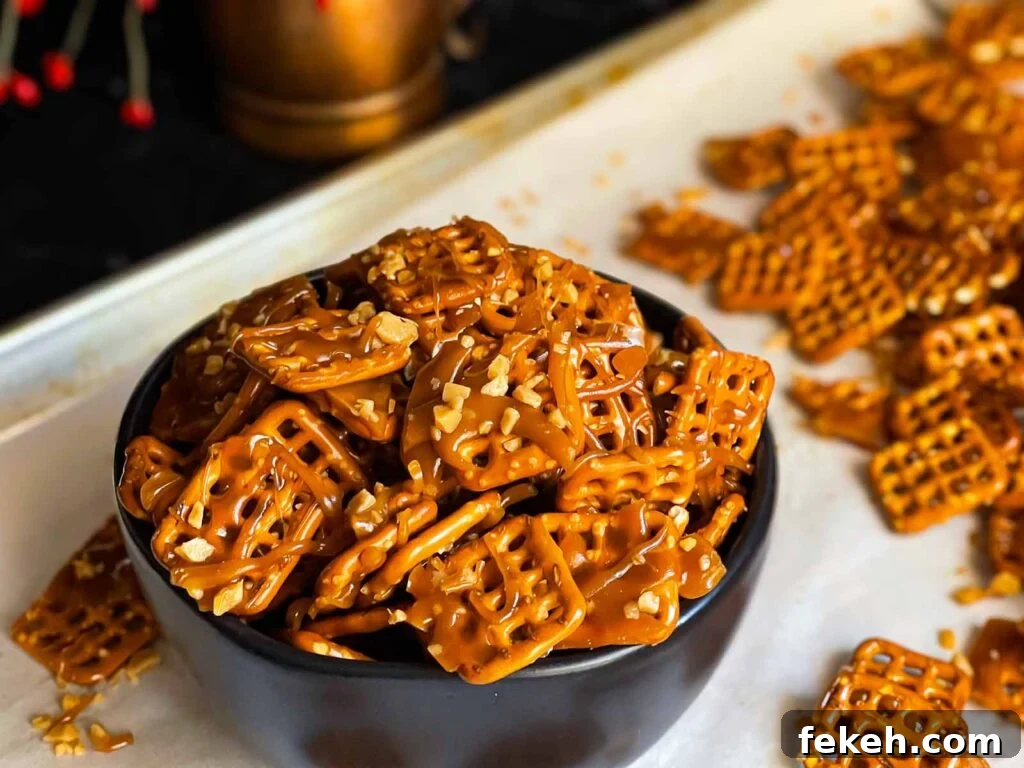 Crunchy Butter Toffee Pretzel Recipe — Sweet & Salty Treat 2 Butter toffee pretzels in a dark bowl on the baking sheet.