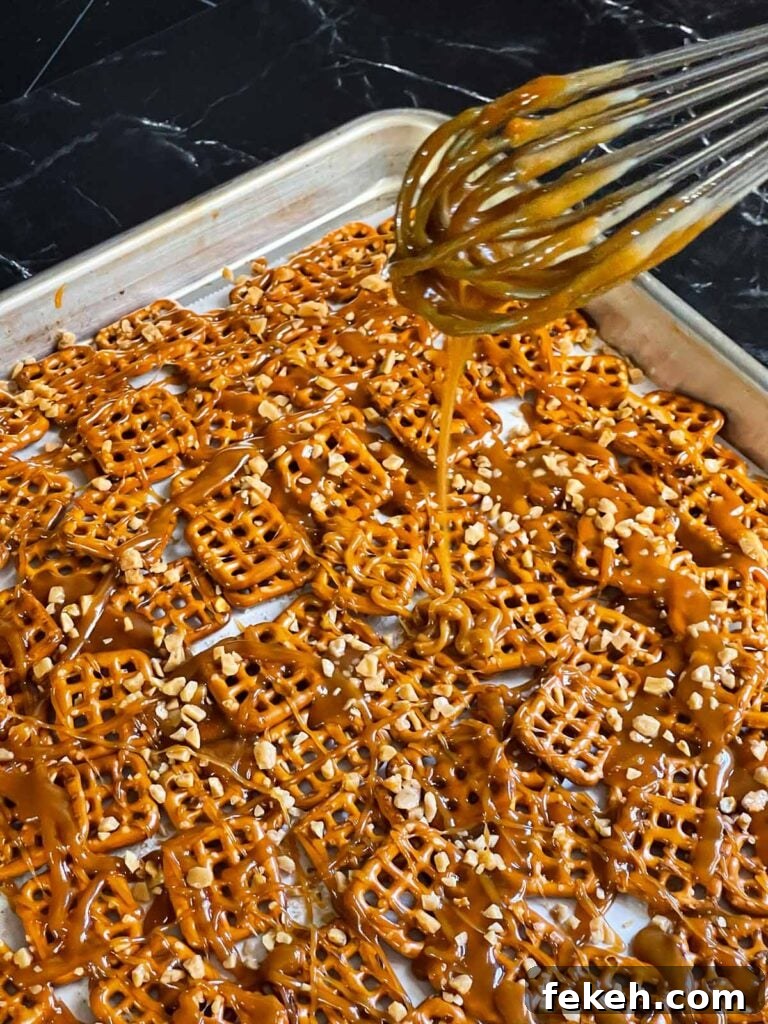 Crunchy Butter Toffee Pretzel Recipe — Sweet & Salty Treat 6 Butter toffee being drizzled over the pretzels in a baking sheet.
