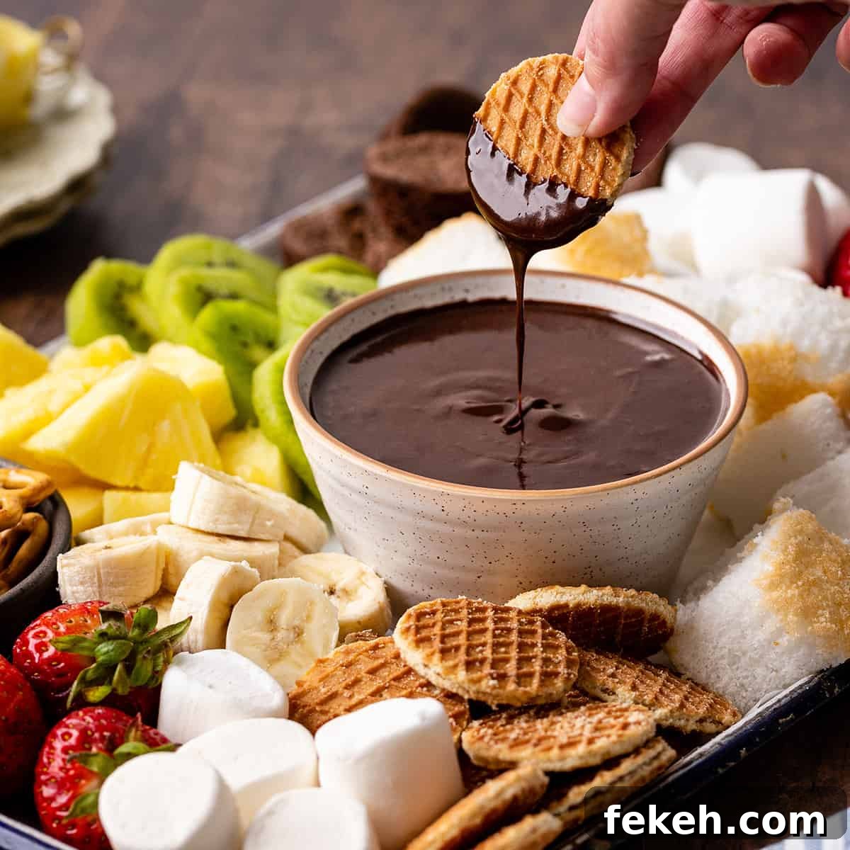 Decadent Chocolate Fondue Recipe for Dipping Fruit & Treats 5 a cookie being dipped into Chocolate Fondue