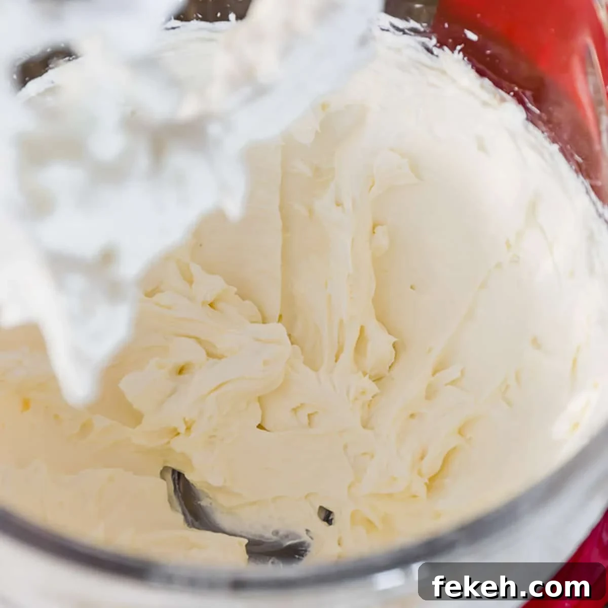 Cream Cheese Frosting Recipe: Smooth, Tangy Icing for Cakes and Cupcakes 4 Whipped cream cheese and butter in a glass bowl of stand mixer.
