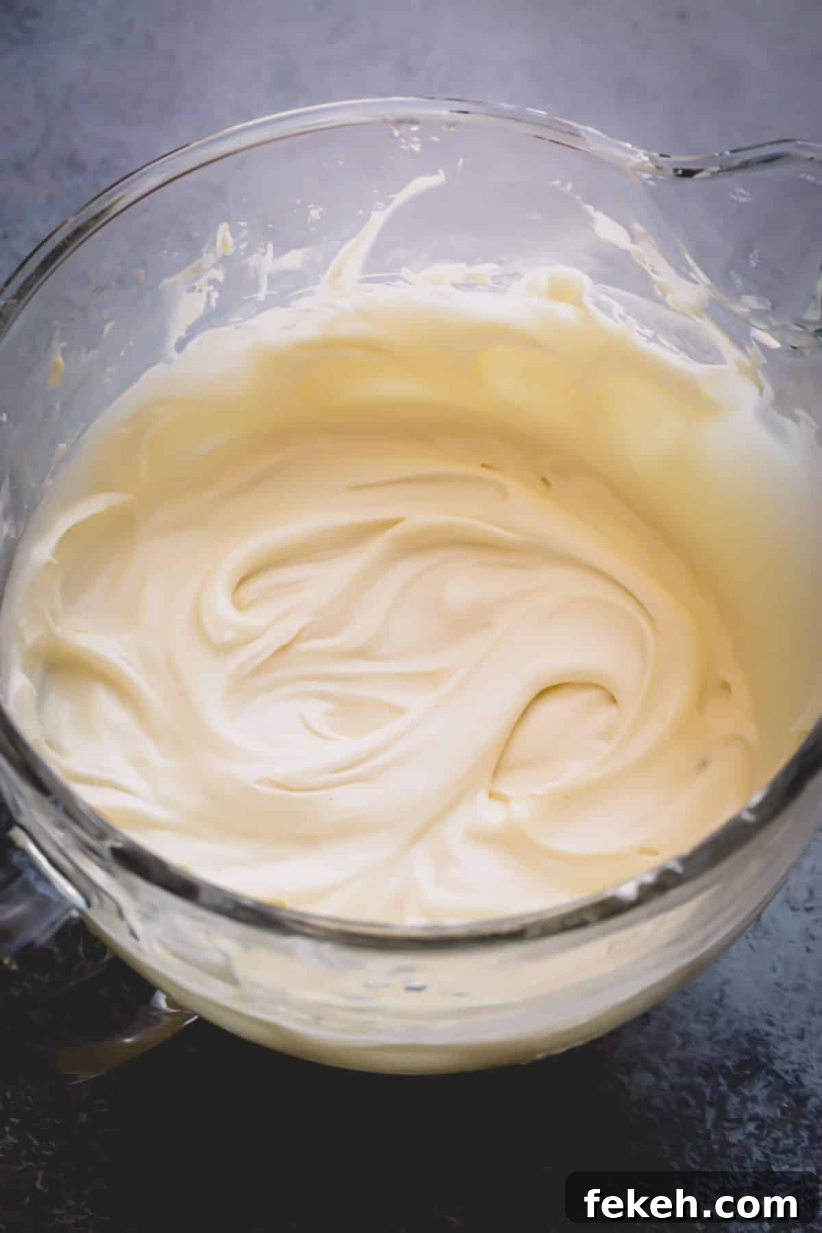 Cream Cheese Frosting Recipe: Smooth, Tangy Icing for Cakes and Cupcakes 6 A glass bowl of smooth frosting.