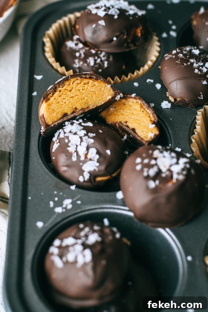 Peanut Butter Truffles with Lighter Ingredients and Less Sugar 2 peanut butter chocolate truffles with flaky sea salt in a cupcake tin