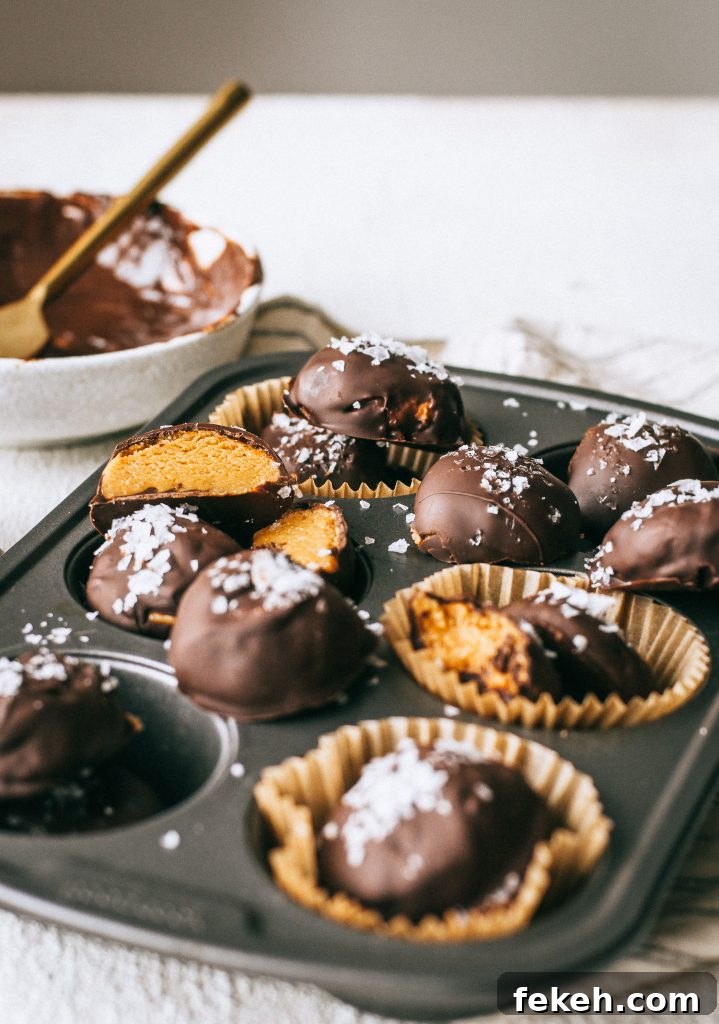 Peanut Butter Truffles with Lighter Ingredients and Less Sugar 4 peanut butter chocolate truffles with flaky sea salt in a cupcake tin with a bowl of melted chocolate