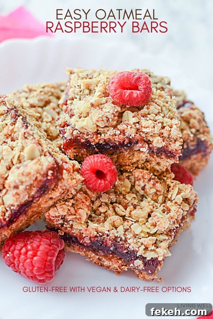 raspberry oatmeal bars stacked together with fresh raspberries on top
