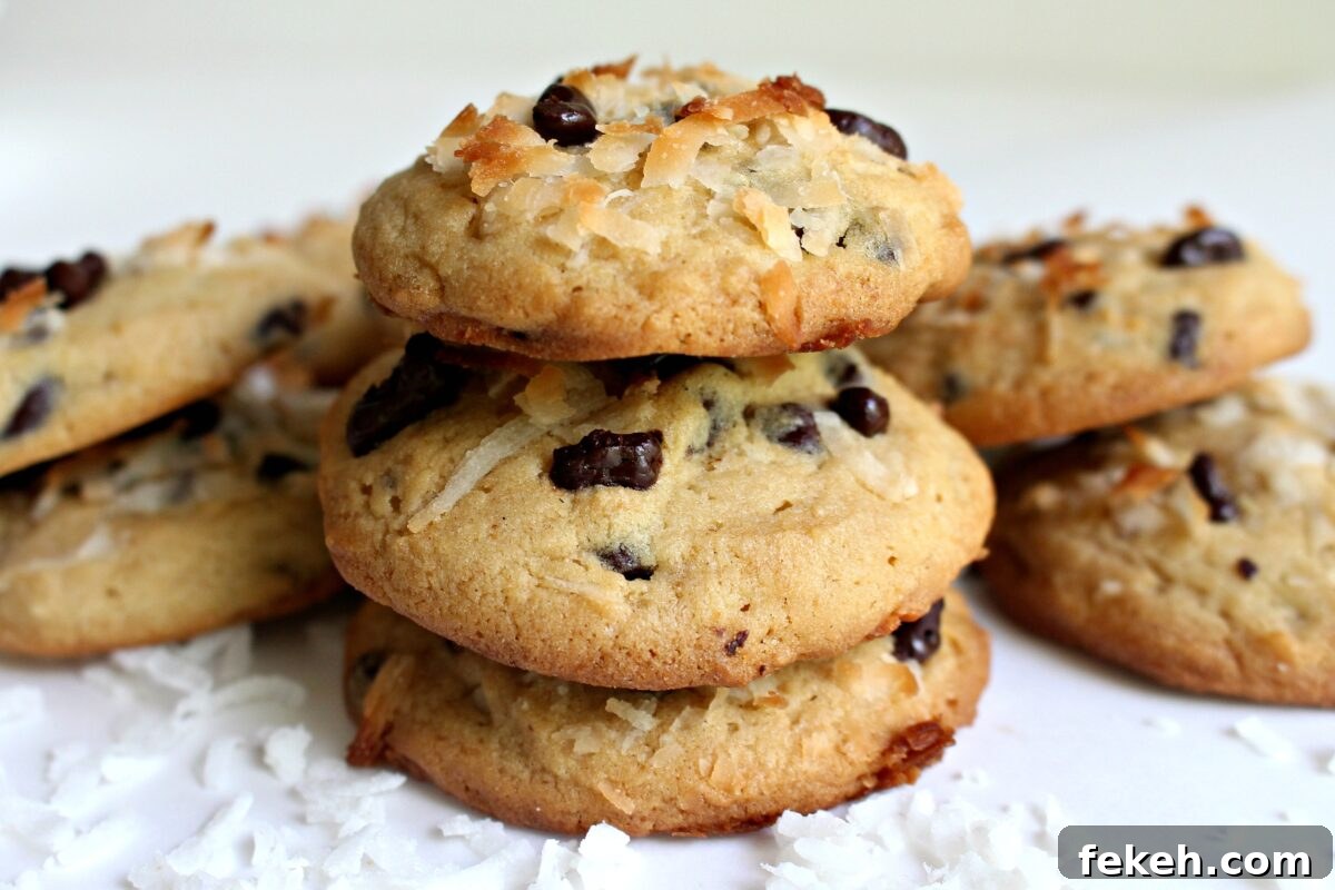 Coconut Milk Cookies get their luscious tropical flavor from coconut milk plus shredded coconut. Cacao nibs add crunch! Stack of three cookies topped with cocoa nibs and shredded coconut.