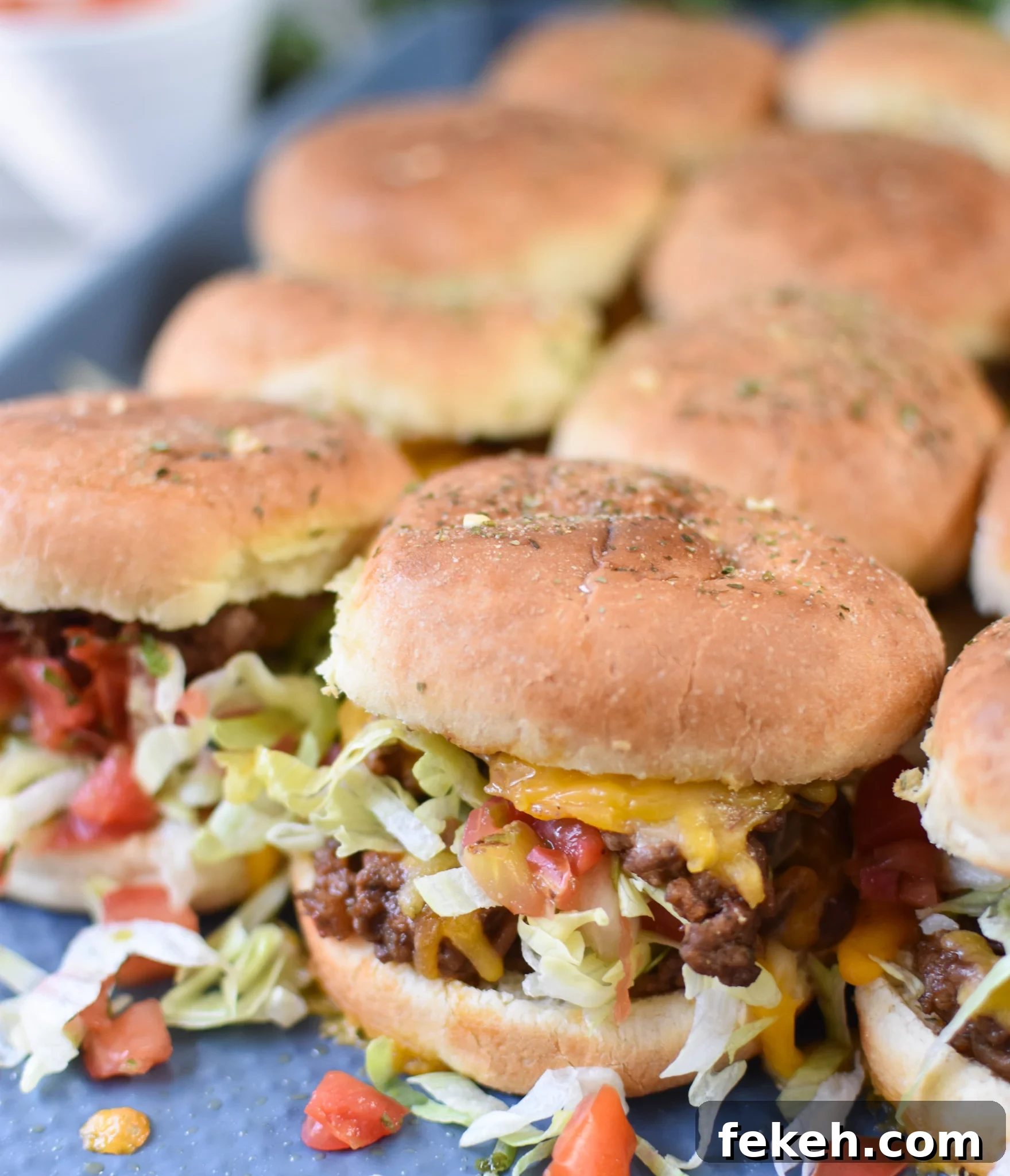 Taco Beef Sliders: Quick Party Sliders with Spicy Beef & Cheese 2 Taco Beef Sliders on a baking sheet.