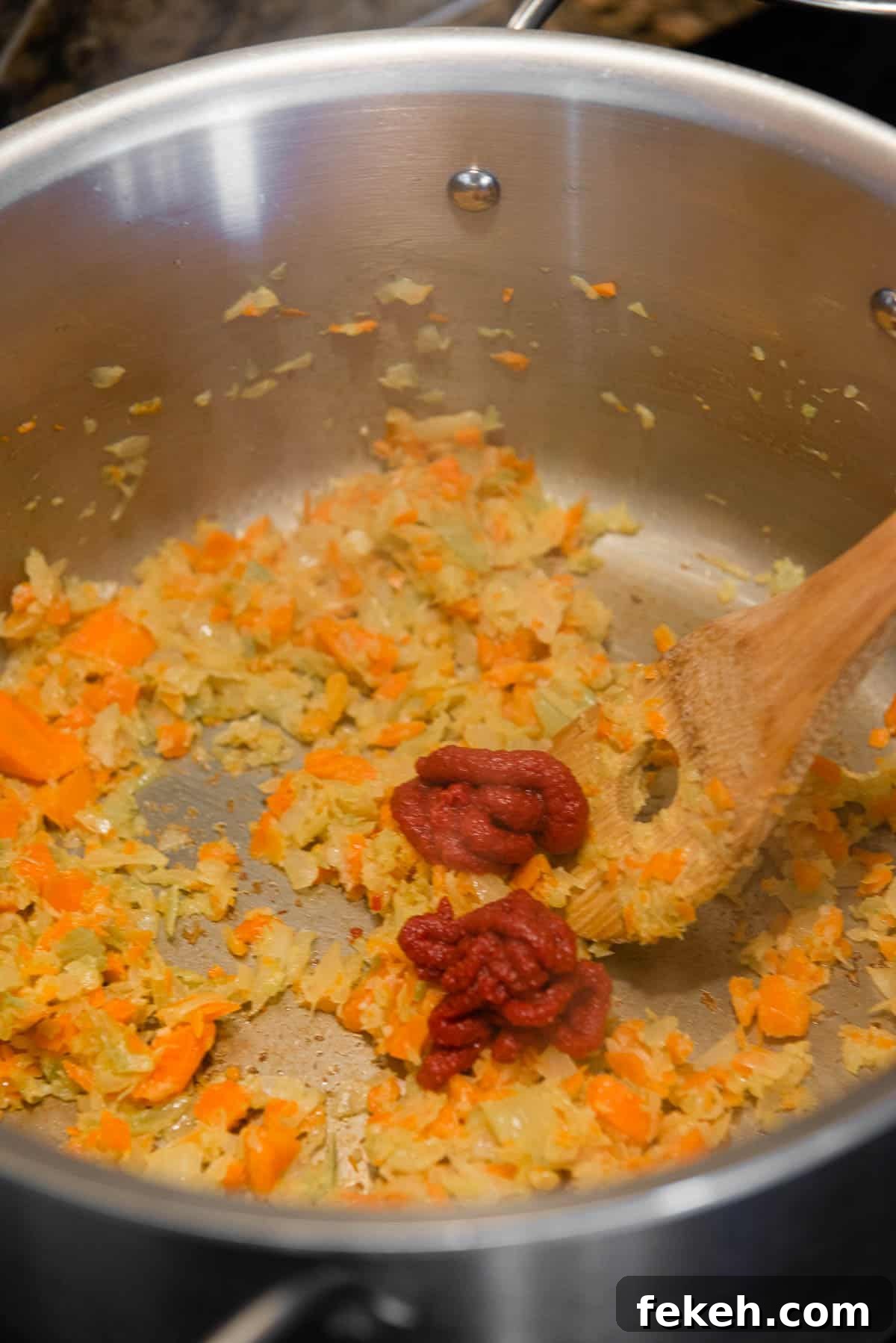 adding tomato paste to mirepoix