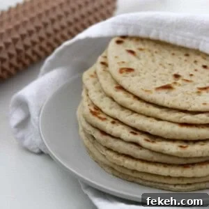 Soft Swedish Tunnbröd: Authentic Homemade Flatbread Recipe 6 Soft Swedish Flatbreads on a plate next to a towel and a spiky rolling pin.