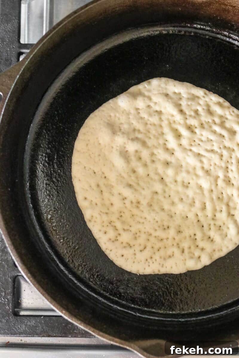 Soft Swedish Tunnbröd: Authentic Homemade Flatbread Recipe 4 Flatbread cooking in a cast iron skillet.