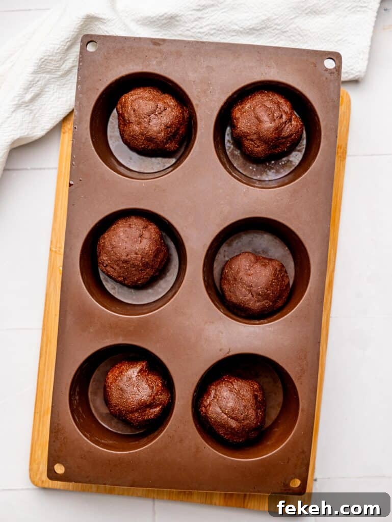No-Bake Mini Triple Chocolate Cheesecakes Recipe 11 No Bake Chocolate Cheesecake Crust in muffin tray cavities.