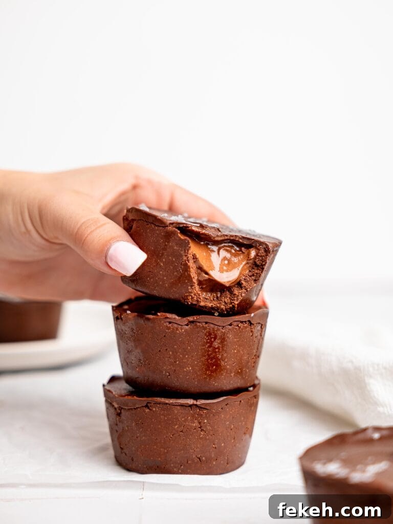 No-Bake Mini Triple Chocolate Cheesecakes Recipe 20 Three triple chocolate cheesecakes stacked on top of each other, the top one shows the filling.