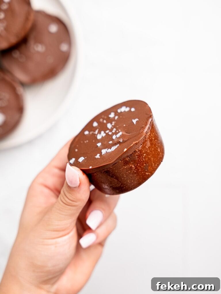 No-Bake Mini Triple Chocolate Cheesecakes Recipe 7 A hand holding a mini triple chocolate cheesecake.