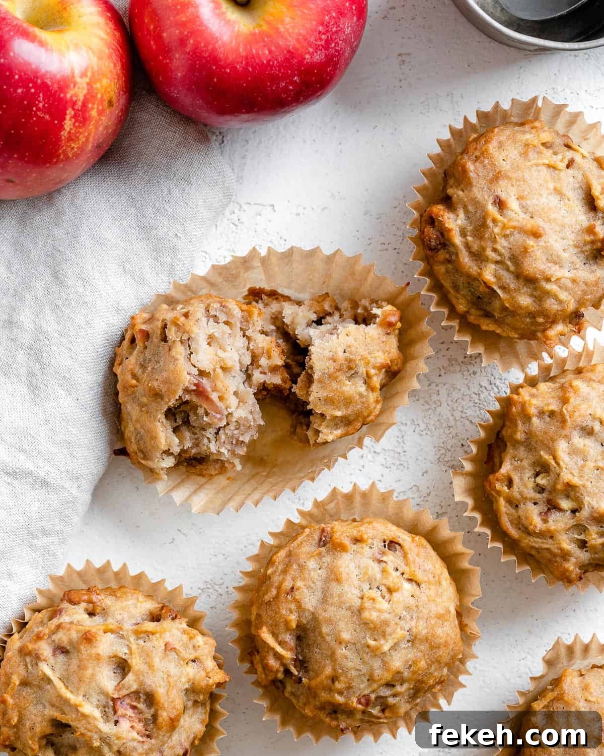 several completed Vegan Apple Muffins spread out on a white surface