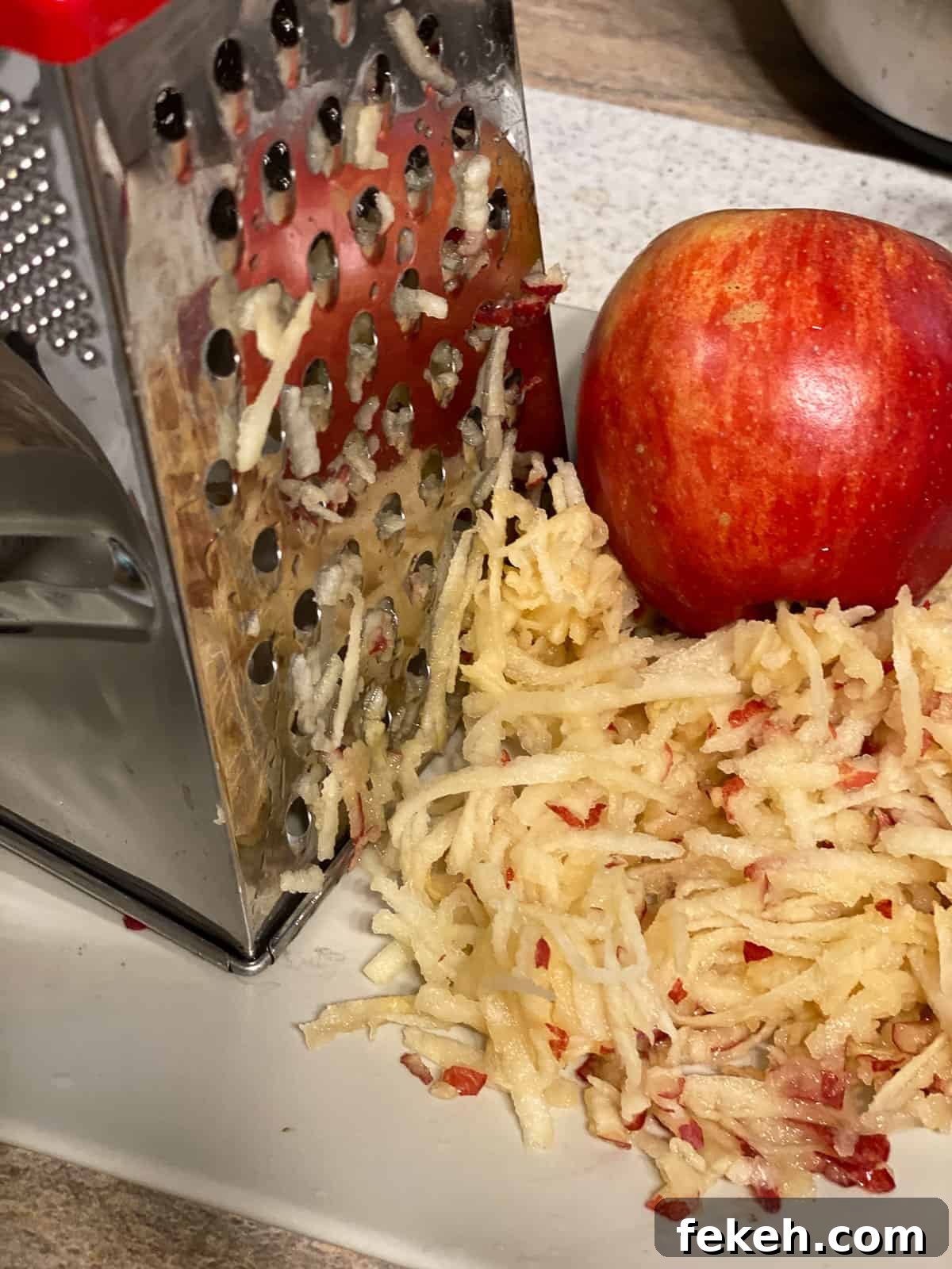 process shot of grating apples with apple in the background