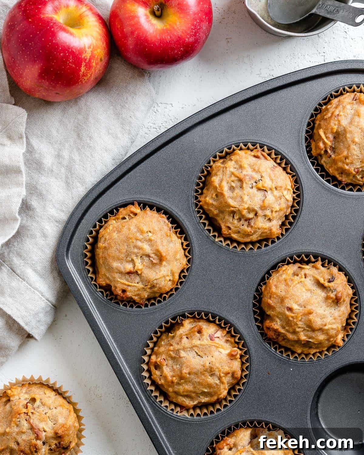 several completed Vegan Apple Muffins spread out on a white surface