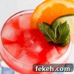 Refreshing Watermelon Mocktail Recipe for Summer Parties 11 Overhead photo of a watermelon drink in a glass with limes, mint and oranges on the side.
