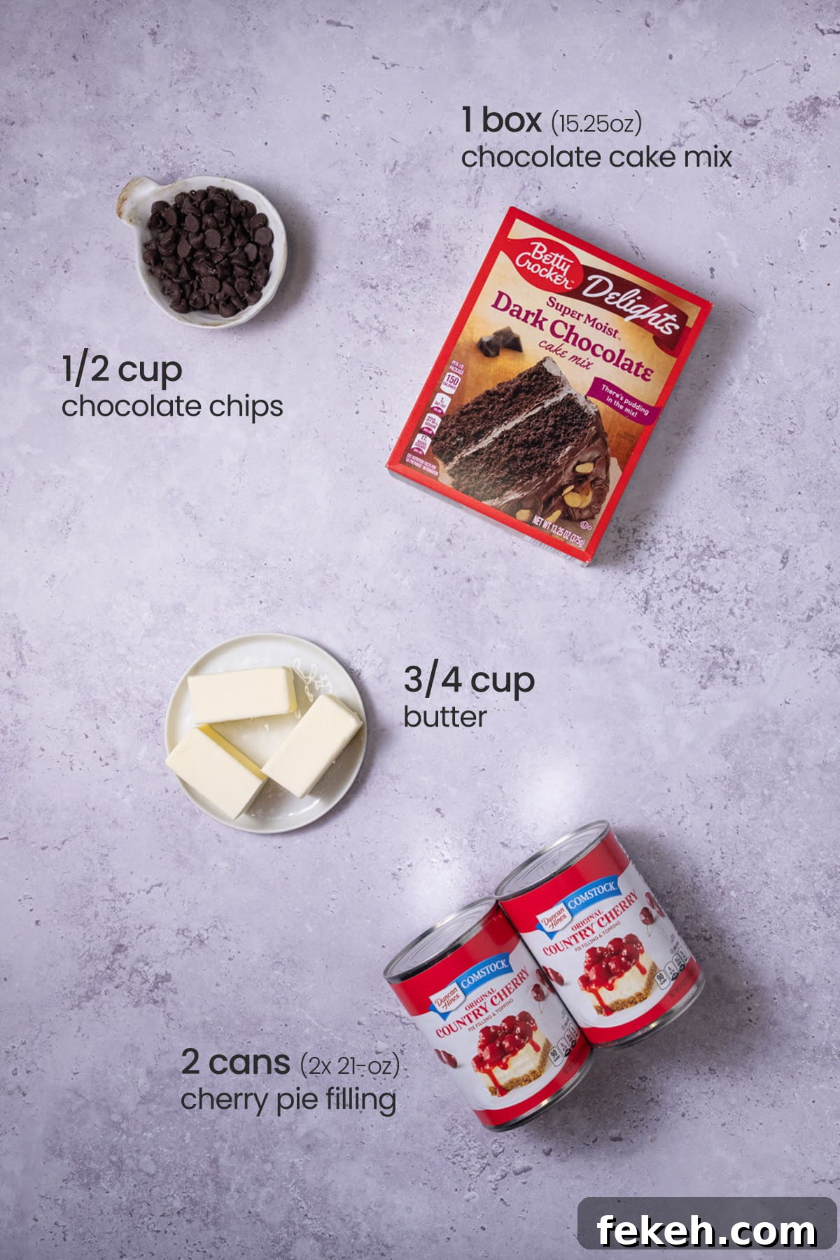 4-Ingredient Chocolate Cherry Dump Cake Recipe 3 Overhead view of the ingredients needed for chocolate cherry dump cake - chocolate chips, chocolate cake mix, butter, and cherry pie filling.