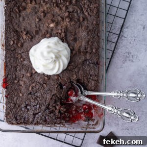 4-Ingredient Chocolate Cherry Dump Cake Recipe 8 Close crop of chocolate cherry dump and bake cake with a serving scooped out to show the cherry pie filling underneath.