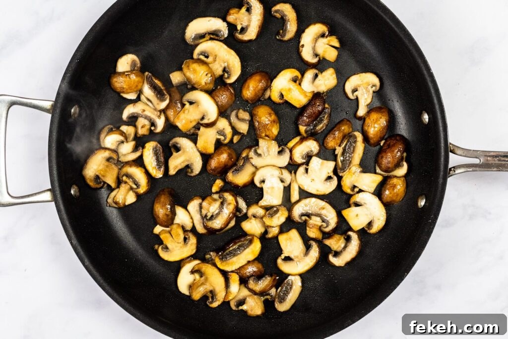 Creamy Garlic Mushroom Pasta Recipe: Rich, Silky Dinner Idea 4 Mushrooms cooking in a skillet.