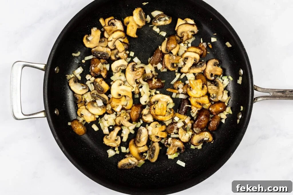 Creamy Garlic Mushroom Pasta Recipe: Rich, Silky Dinner Idea 5 Mushrooms, shallots and garlic cooking in a skillet.