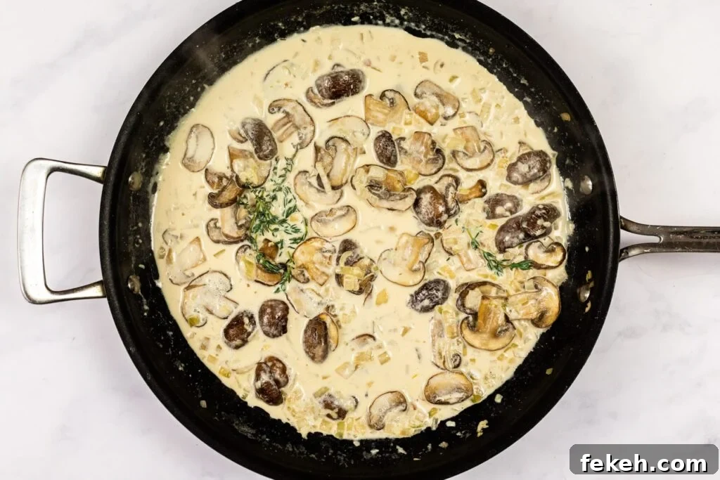Creamy Garlic Mushroom Pasta Recipe: Rich, Silky Dinner Idea 7 Creamy mushroom sauce reducing in a skillet.