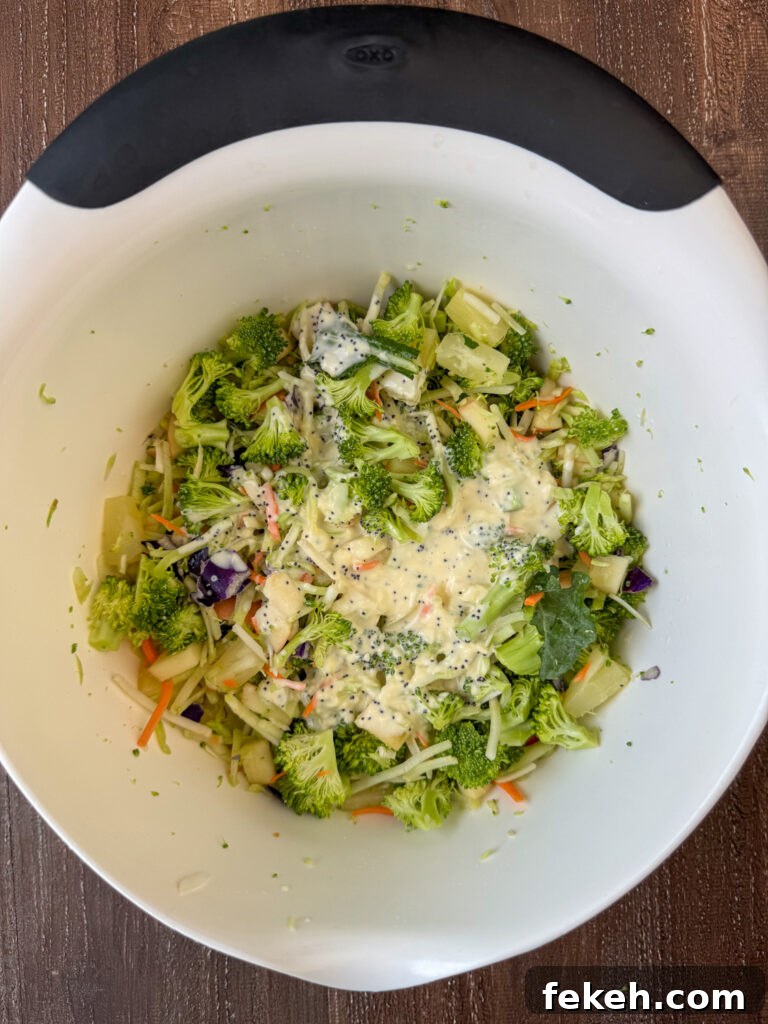 Creamy Broccoli Slaw with Crunchy Apples and Almonds 6 Three ingredient homemade dressing poured over a bowl of broccoli slaw salad.