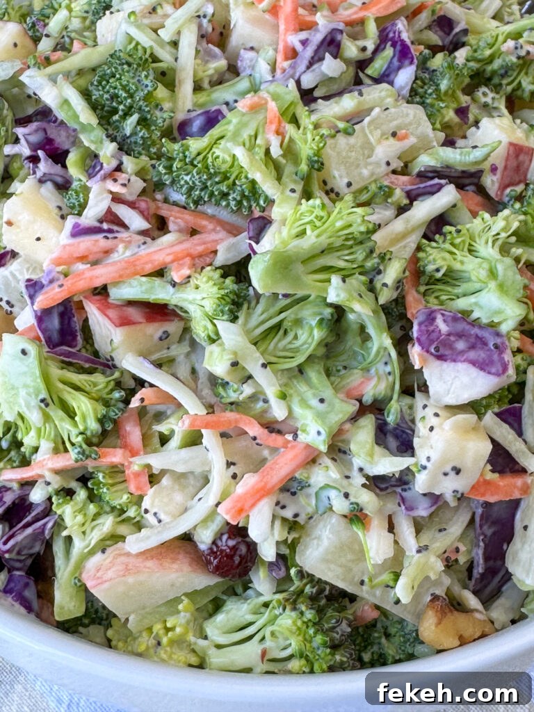 Creamy Broccoli Slaw with Crunchy Apples and Almonds 10 Close up small pieces of shredded broccoli with pineapple, apples, carrots and red cabbage mixed up and coated with a fruity and creamy dressing to make an easy broccoli slaw recipe.