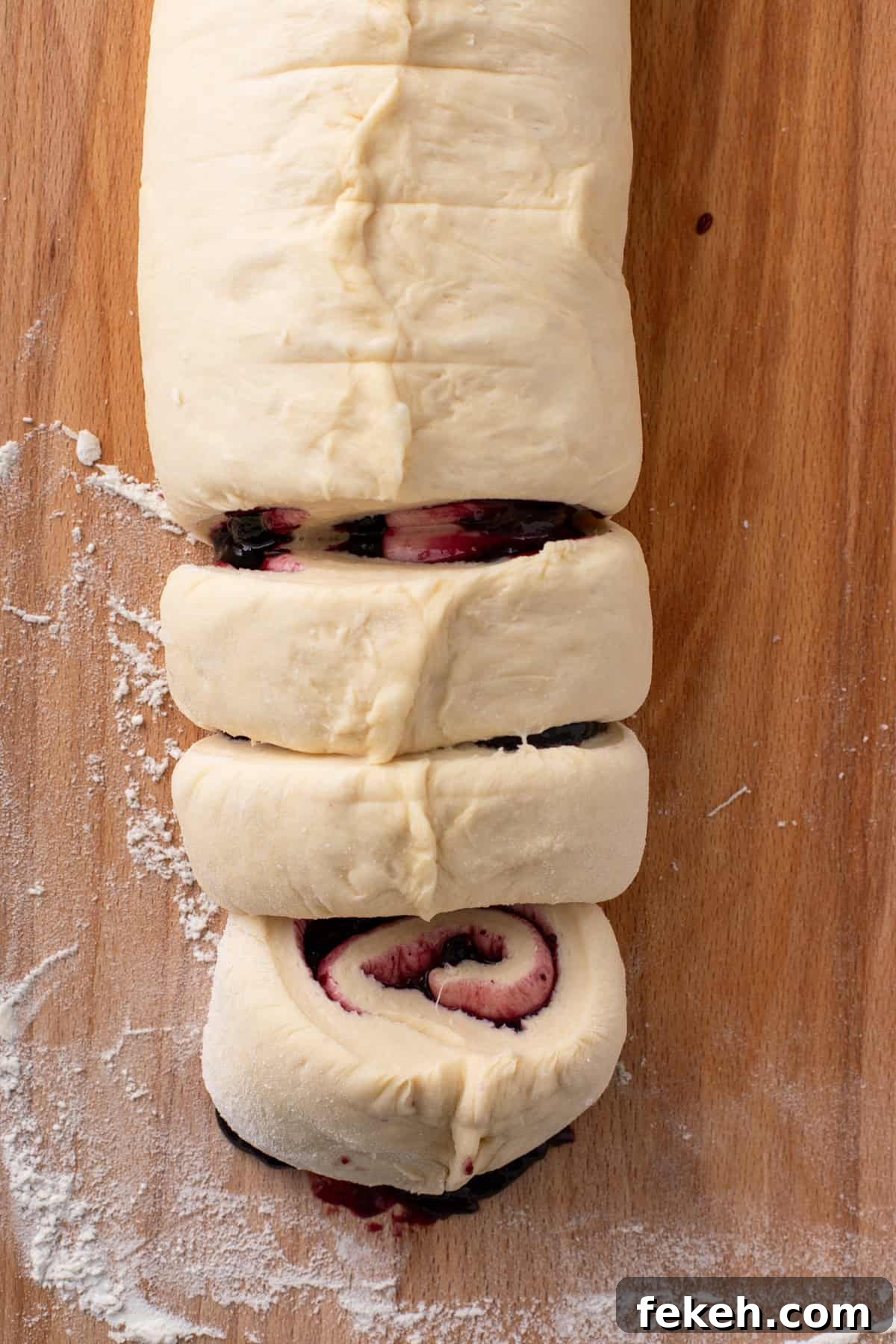 Sweet roll dough filled with blueberry preserves and rolled, then cut into pieces.